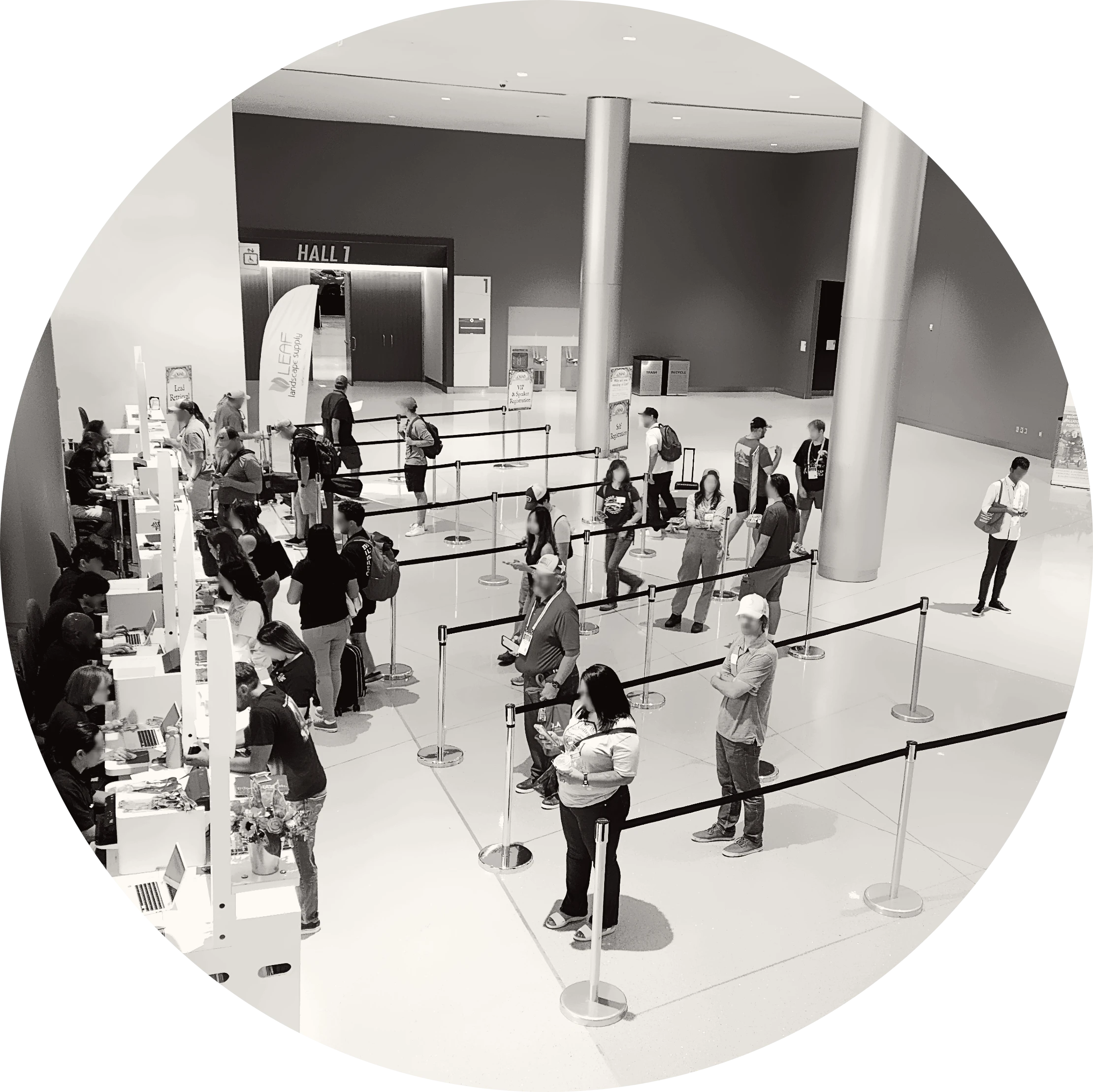 Attendees queueing and being assisted at registration counters